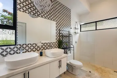 a bathroom with two sinks and a toilet at Sprawling Modern Property with a Tranquil Outdoor Living Space swimming pool and a private Casita in Playa Flamingo