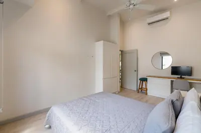 a white bedroom with a bed and a desk at Sprawling Modern Property with a Tranquil Outdoor Living Space swimming pool and a private Casita in Playa Flamingo