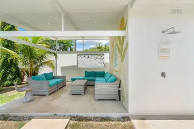 a patio with two couches and blue cushions at Sprawling Modern Property with a Tranquil Outdoor Living Space swimming pool and a private Casita in Playa Flamingo