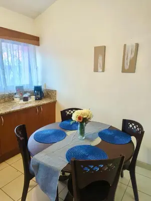 a dining room table with chairs and a vase of flowers at Garza Real in Coco