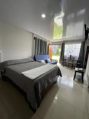 a bedroom with a large bed and a living room at Castro's Apartment in Fortuna
