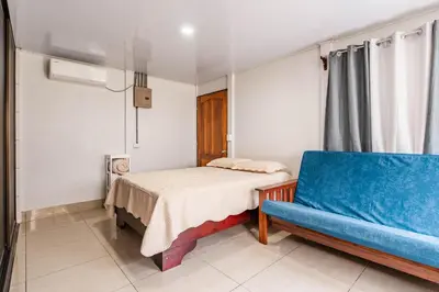 a bedroom with a bed and a blue couch at Castro's Apartment in Fortuna