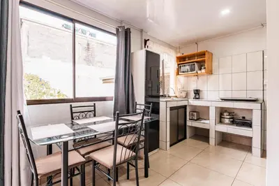 a kitchen with a table and chairs and a table and a window at Castro's Apartment in Fortuna