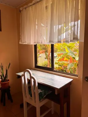 a table and a chair in front of a window at Vista Serena in San Isidro