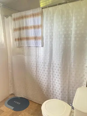 a bathroom with a toilet and a shower curtain at Vista Serena in San Isidro