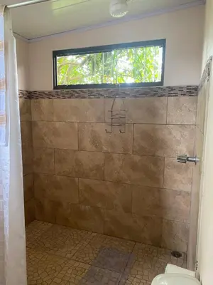 a bathroom with a shower with a toilet and a window at Vista Serena in San Isidro
