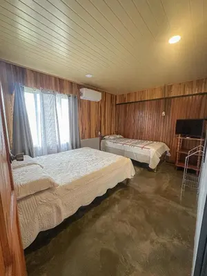 two beds in a room with wooden walls at Blanca's House in Fortuna