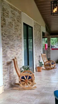 three wooden chairs sitting on a porch at House in the Woods in Guápiles
