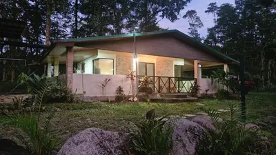 a small house with a white fence in front of it at House in the Woods in Guápiles