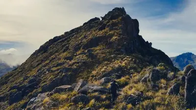 a man standing on the side of a mountain at Route to Cerro Urán - Chirripó in Rivas