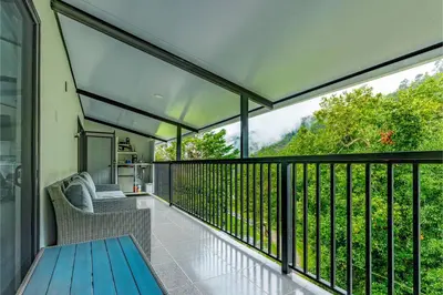 a balcony with a blue table and chairs on it at Route to Cerro Urán - Chirripó in Rivas