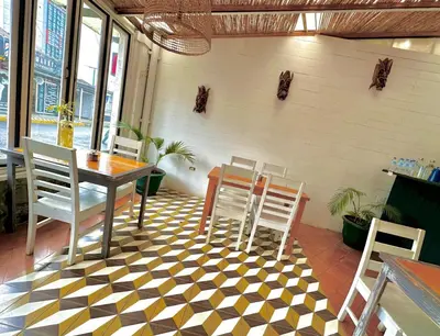 a restaurant with a table and chairs on a checkered floor at Luz de Luna Barrio Escalante in San José