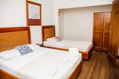 a bedroom with two beds and a cabinet at Luz de Luna Barrio Escalante in San José
