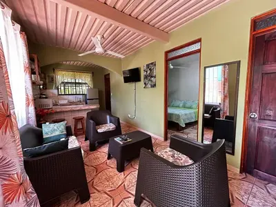 a living room with couches and chairs and a bedroom at Apartment 5 -10 minutes away BY CAR from Manuel Antonio beach! in Quepos