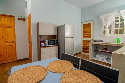 a kitchen with a table and a refrigerator at Villas Mali La Fortuna in Guayabal