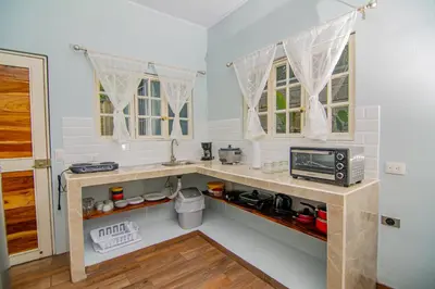 a kitchen with a counter with a sink and a microwave at Villas Mali La Fortuna in Guayabal