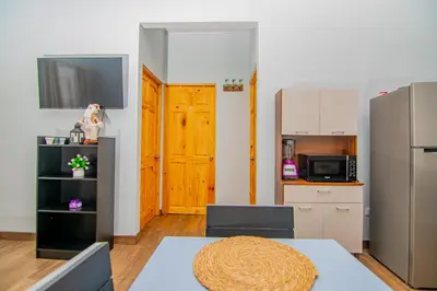 a small kitchen with a table and a refrigerator at Villas Mali La Fortuna in Guayabal