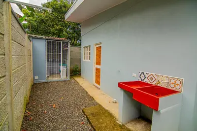 a red bench sitting on the side of a building at Villas Mali La Fortuna in Guayabal