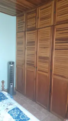a bedroom with wooden lockers and a bed in it at Altos de Montenegro Alajuela in Alajuela City