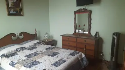 a bedroom with a bed and a dresser and a mirror at Altos de Montenegro Alajuela in Alajuela City