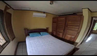 a small bedroom with a bed and wooden cabinets at Lapas House in Esperanza