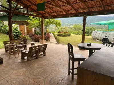 a patio with tables and chairs under a wooden roof at Lapas House in Esperanza