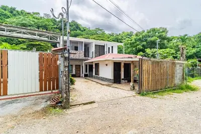 a house with a gate and a fence at Colores Beach Apartments Santa Teresa in Santa Teresa Beach