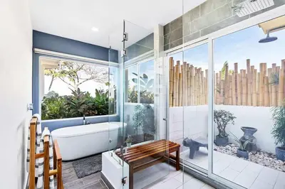 a bathroom with a bath tub and a glass wall at 4BR Villa Oceanview and Infinity Pool in Brasilito