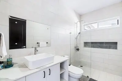 a white bathroom with a sink and a toilet at 4BR Villa Oceanview and Infinity Pool in Brasilito