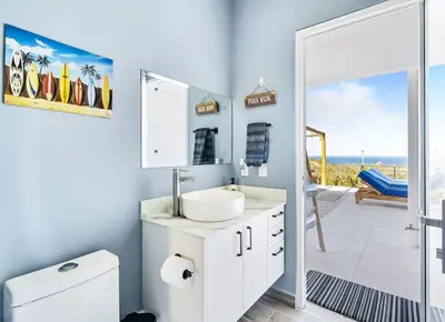 a white bathroom with a sink and a view of the ocean at 4BR Villa Oceanview and Infinity Pool in Brasilito