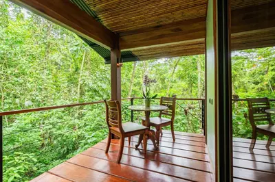 a screened in porch with a table and chairs on it at Secret Bungalows Lechu in Fortuna
