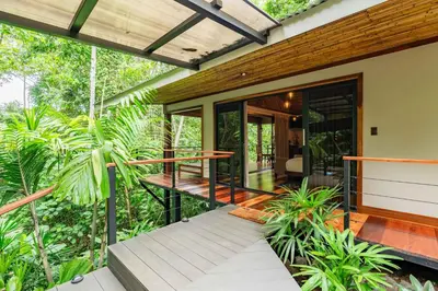a house in the middle of a forest with a porch at Secret Bungalows Lechu in Fortuna