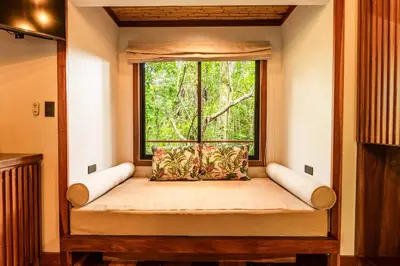a window seat in a room with a large window at Secret Bungalows Lechu in Fortuna
