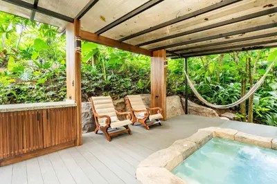 an outdoor patio with a hot tub and chairs at Secret Bungalows Lechu in Fortuna
