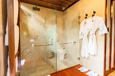 a shower with a glass door in a bathroom at Secret Bungalows Lechu in Fortuna