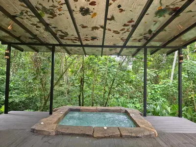 an outdoor hot tub in a pavilion in the woods at Secret Bungalows Lechu in Fortuna