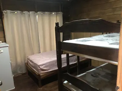 a bedroom with a bunk bed and a window at Cabaña El Bosque in Turrialba