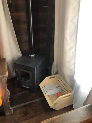 a wood stove in a room with a box at Cabaña El Bosque in Turrialba