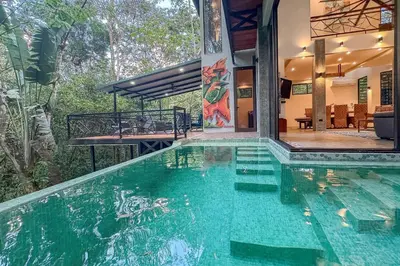 a swimming pool in the middle of a house at Casa de Agua, A Jungle Retreat in Manuel Antonio in Manuel Antonio