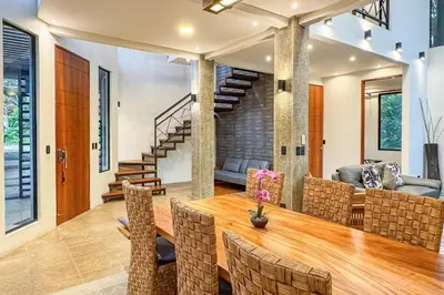 a dining room with a wooden table and chairs at Casa de Agua, A Jungle Retreat in Manuel Antonio in Manuel Antonio