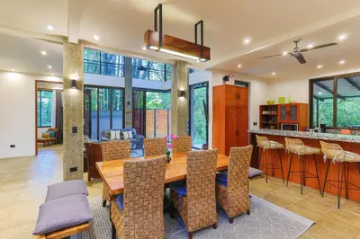 a dining room with a wooden table and chairs at Casa de Agua, A Jungle Retreat in Manuel Antonio in Manuel Antonio