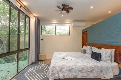 a bedroom with a bed and a ceiling fan at Casa de Agua, A Jungle Retreat in Manuel Antonio in Manuel Antonio