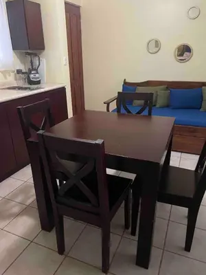 a dining table and chairs in a kitchen with a couch at Marina Loft in Coco