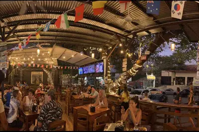 a group of people sitting at tables in a restaurant at Marina Loft in Coco