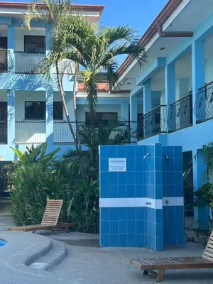 a blue and white building with two chairs and palm trees at Marina Loft in Coco