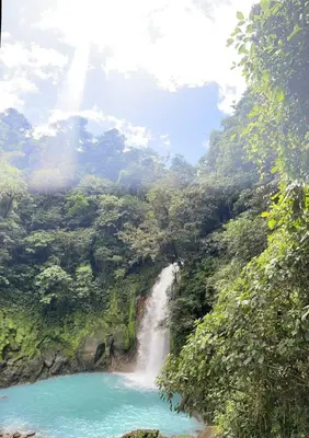 a waterfall in the middle of a forest next to a river at Marina Loft in Coco