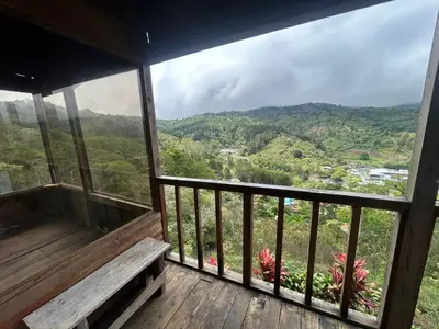 a balcony with a bench and a view of the mountains at Cabañas la esperancita in Guatuso
