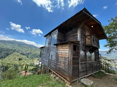 a wooden house sitting on top of a hill at Cabañas la esperancita in Guatuso