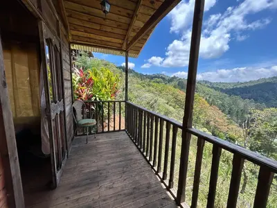 a balcony of a house with a view of the mountains at Cabañas la esperancita in Guatuso