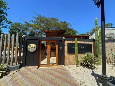 a building with a door and a fence at Casa Aura: Beachfront Premium Hostel in Tamarindo